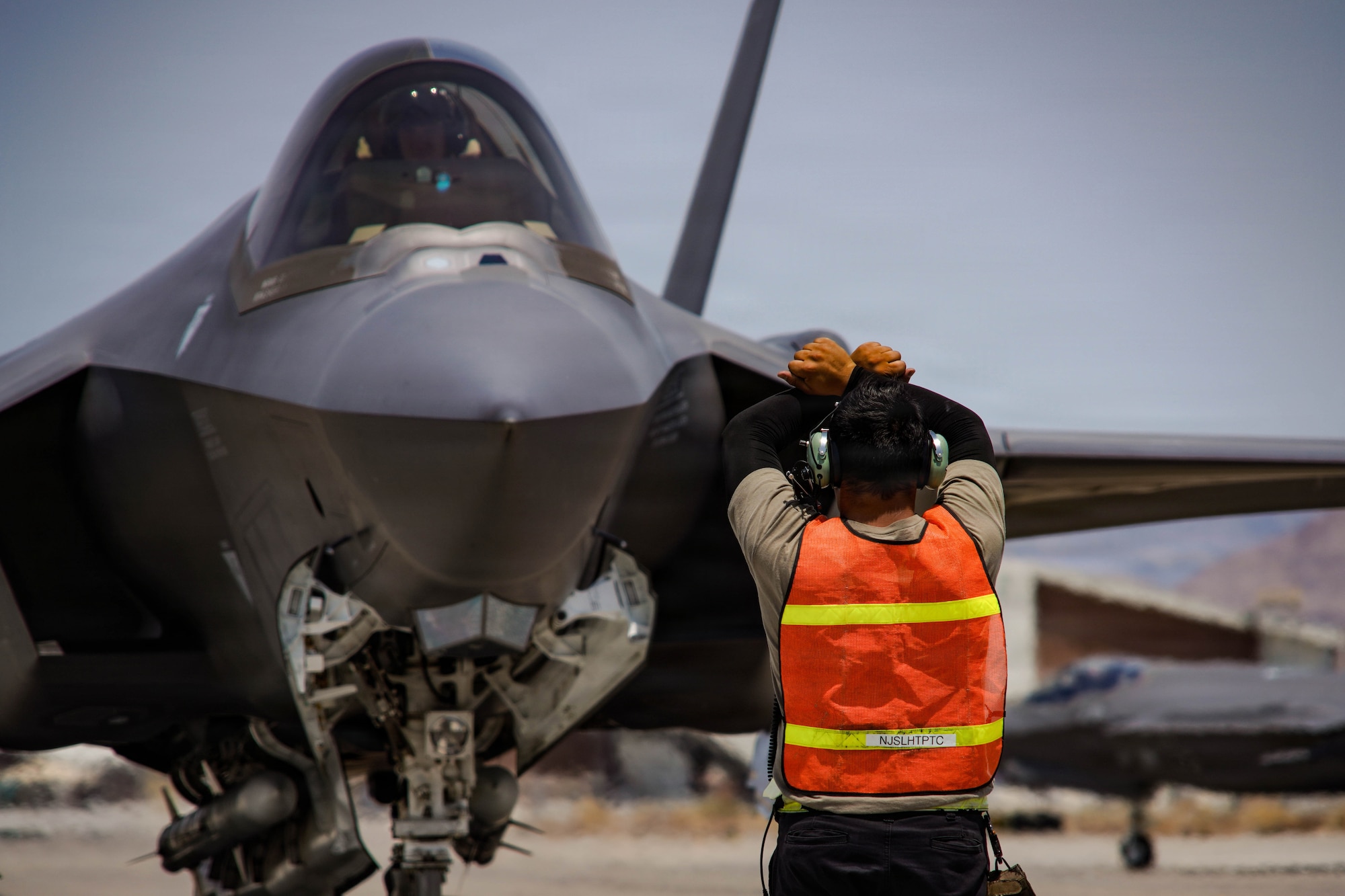 A U.S. Air Force F-35A Lightning II aircraft assigned to the 65th Aggressor Squadron gets marshalled on the flightline at Creech Air Force Base, Nevada, June 17, 2026. Exercise VENOM FORGE is an in-house, limited-scope, targeted event designed to develop and test critical thinking, planning and execution across the logistics enterprise, maintenance, munitions and logistics. (U.S. Air Force photo by Staff Sgt. Jake Jacobsen)