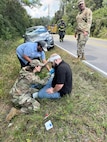 Montana Air Guard Capt. Caitlyn Cayer, who is also a nurse practitioner, administers aid to a man involved in a traffic wreck in Gulfport, Miss., Sept. 22, 2025. Master Sgt. Kraig Kimball, top right, helped pull the driver from a car fire and escorted him to safety seconds before the car engulfed in flames.