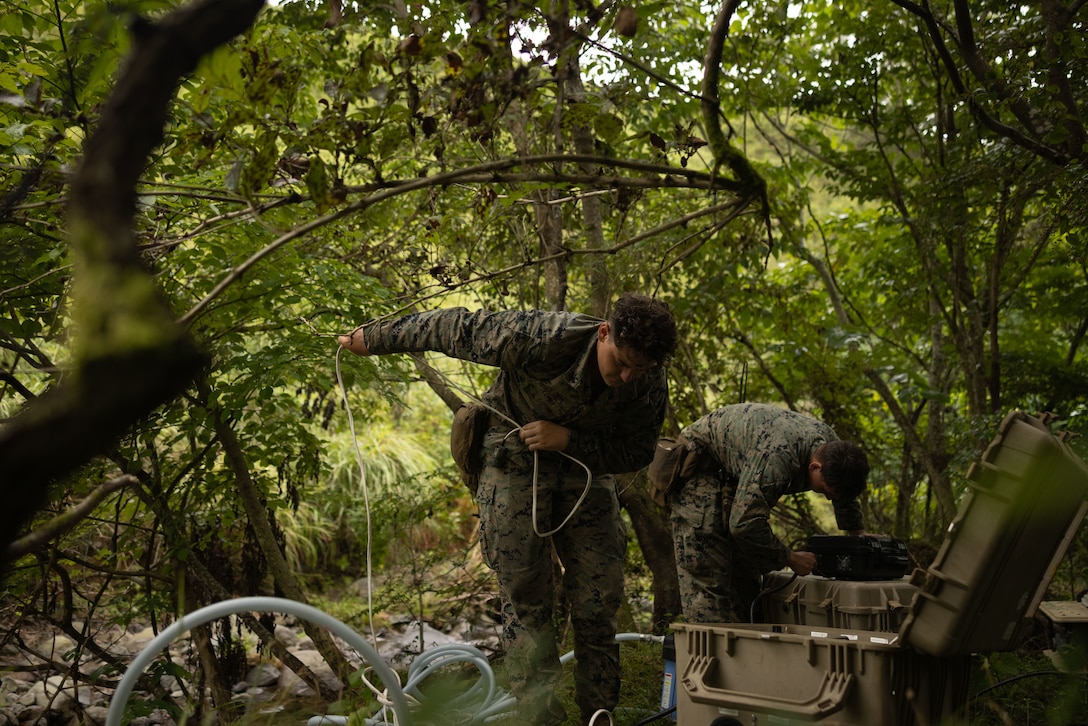 U.S. Marine Corps Lance Cpl. Gabriel Combs, left, and Lance Cpl. Christopher Elam, both water support technicians with 12th Littoral Logistics Battalion, 12th Marine Littoral Regiment, 3rd Marine Division, employ a Lightweight Water Purification System during Resolute Dragon 25 at Oyanohara Maneuver Area, Oita, Japan, Sept. 17, 2025. Resolute Dragon is an annual bilateral exercise in Japan that strengthens the command, control, and multi-domain maneuver capabilities of U.S. Marines in III Marine Expeditionary Force and Japan Self-Defense Force personnel, with a focus on controlling and defending key maritime terrain. Combs is a native of Utah and Elam is a native of Kentucky. (U.S. Marine Corps photo by Lance Cpl. Robert Blanks)