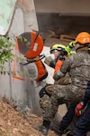 U.S. Air Force Tech. Sgt. Waylon Dashiell, 141st Civil Engineers, Washington Air National Guard, cuts a concrete wall alongside the Bangkok Fire and Rescue Department during the humanitarian assistance disaster relief demonstration, part of Exercise Cobra Gold 2026 at the Disaster Relief Training Centre, Phanom Sarakham District, Chachoengsao, Thailand, Feb. 27, 2026. The U.S. and Thailand host the 45th annual Cobra Gold from Feb. 24 to Mar. 6, with about 8,000 participants from 30 nations to engage in military training and humanitarian projects. The exercise strengthens regional partnerships and demonstrates U.S. commitment to Indo-Pacific security. Photo by Sgt. Matthew Sprowl.