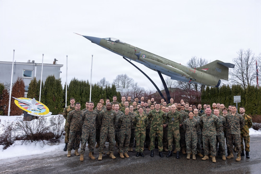 Norwegian Armed Forces personnel, U.S. Marines, and Sailors with the exercise Cold Response 26 Combined Joint Logistics Support Group pose for a group photo after a transfer of authority ceremony at Kjeller Air Base, Norway, Feb. 27, 2026. A key component of NATO's enhanced vigilance activity Arctic Sentry, exercise Cold Response 26 is a Norwegian-led winter military exercise designed to enhance collective defense capabilities and ensure U.S. readiness to rapidly deploy and seamlessly operate alongside NATO Allies in challenging arctic conditions. (U.S. Marine Corps photo by Sgt. Rafael Brambila-Pelayo)