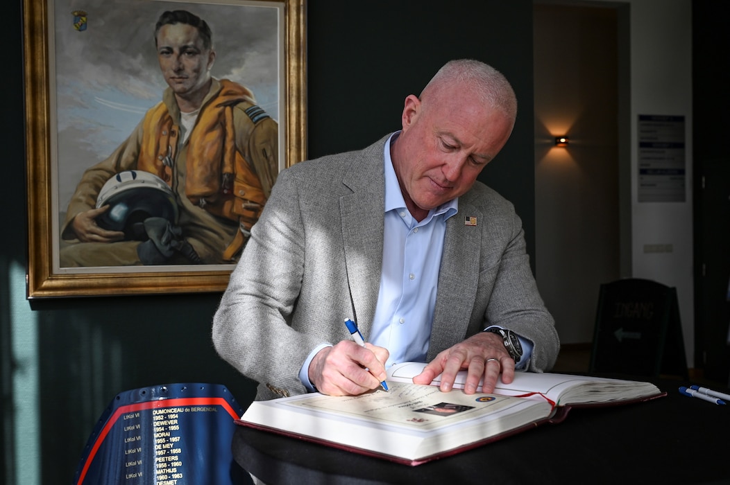 Bill White, U.S. Ambassador to Belgium, writes a farewell message during his base visit.