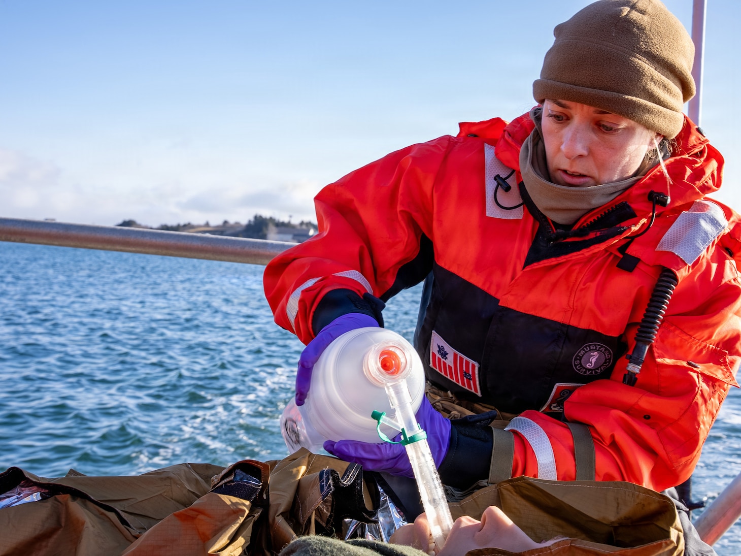 U.S. Navy Lt. Hannah Cunningham, assigned to En-route Care System (ERCS) Team 52, treats a patient aboard a Rigid Hull Inflatable Boat (RHIB) during a ship-to-shore medical evacuation exercise as part of ARCTIC EDGE 2026 (AE26) in Kodiak, Alaska, Feb. 26, 2026. AE26 is a NORAD and U.S. Northern Command-led homeland defense exercise designed to improve readiness, demonstrate capabilities, and enhance Joint and Allied Force interoperability in the Arctic. (U.S. Navy photo by Mass Communication Specialist 1st Class Abigayle Lutz)