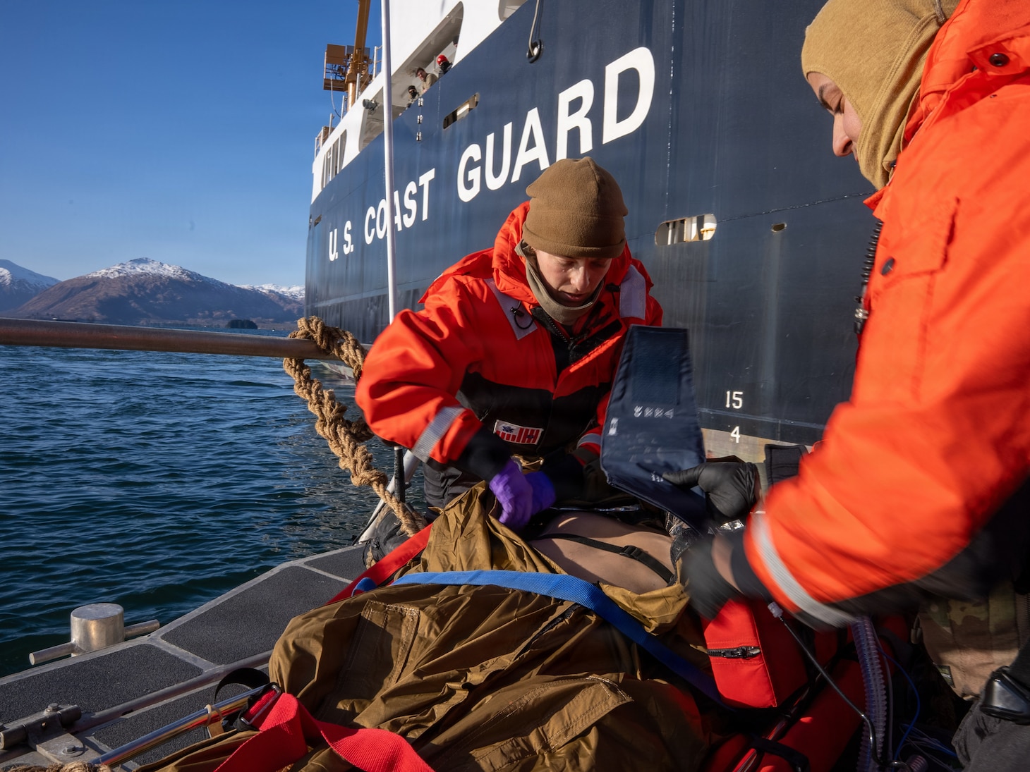 U.S. Navy Lt. Hannah Cunningham, left, assigned to En-route Care System (ERCS) Team 52, and U.S. Navy Hospital Corpsman 1st Class Daniel Rodriguez, assigned to ERCS Team 52, treat a patient aboard a Rigid Hull Inflatable Boat (RHIB) during a ship-to-shore medical evacuation exercise as part of ARCTIC EDGE 2026 (AE26) in Kodiak, Alaska, Feb. 26, 2026. AE26 is a NORAD and U.S. Northern Command-led homeland defense exercise designed to improve readiness, demonstrate capabilities, and enhance Joint and Allied Force interoperability in the Arctic. (U.S. Navy photo by Mass Communication Specialist 1st Class Abigayle Lutz)