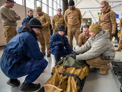 U.S. Coast Guard medical professionals transfer the care of a patient to U.S. Navy Sailors assigned to Expeditionary Resuscitative Surgical System (ERSS) Team 3 during a ship-to-shore medical evacuation exercise as part of ARCTIC EDGE 2026 (AE26) in Kodiak, Alaska, Feb. 26, 2026. AE26 is a NORAD and U.S. Northern Command-led homeland defense exercise designed to improve readiness, demonstrate capabilities, and enhance Joint and Allied Force interoperability in the Arctic. (U.S. Navy photo by Mass Communication Specialist 1st Class Abigayle Lutz)