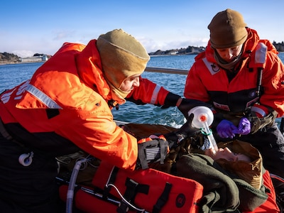 U.S. Navy Hospital Corpsman 1st Class Daniel Rodriguez, left, assigned to En-route Care System (ERCS) Team 52, and U.S. Navy Lt. Hannah Cunningham, right, assigned to ERCS Team 52, treat a patient aboard a Rigid Hull Inflatable Boat (RHIB) during a ship-to-shore medical evacuation exercise as part of ARCTIC EDGE 2026 (AE26) in Kodiak, Alaska, Feb. 26, 2026. AE26 is a NORAD and U.S. Northern Command-led homeland defense exercise designed to improve readiness, demonstrate capabilities, and enhance Joint and Allied Force interoperability in the Arctic. (U.S. Navy photo by Mass Communication Specialist 1st Class Abigayle Lutz)