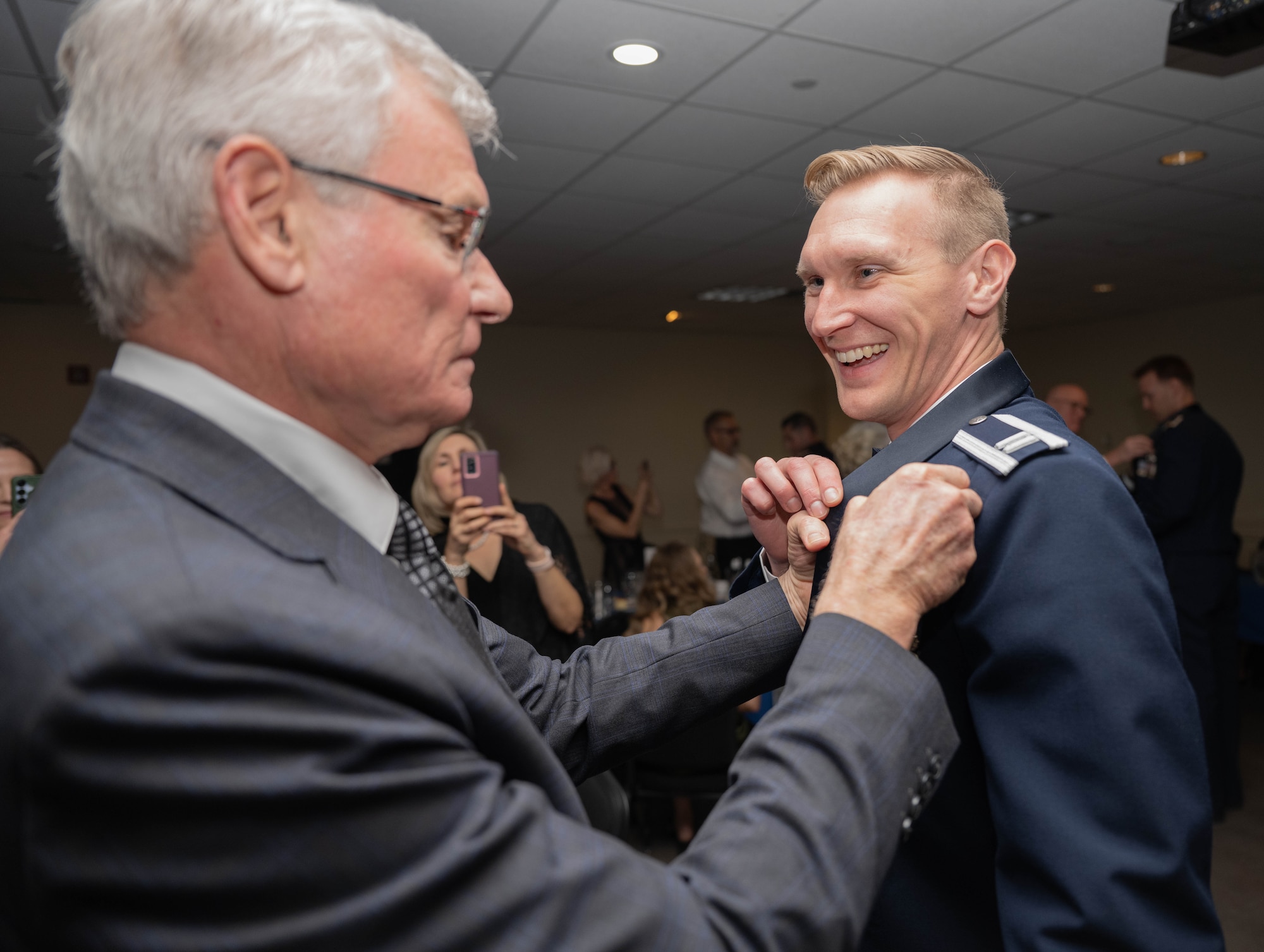 A loved one pins the silver wings onto U.S. Air Force Capt. Joshua Wakefield during the graduation ceremony of Class 26-06 at Laughlin Air Force Base, Texas, Feb. 26, 2026. Graduating student pilots were awarded silver wings as a symbol of completing Undergraduate Pilot Training. (U.S. Air Force photo by Airman 1st Class Darryl Keith)