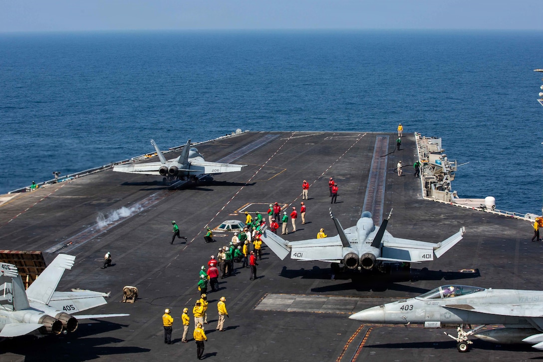 An F/A-18E Super Hornet, attached to Strike Fighter Squadron (VFA) 14, launches, as an F/A-18E Super Hornet, attached to Strike Fighter Squadron (VFA) 151, prepares to launch from the flight deck of Nimitz-class aircraft carrier USS Abraham Lincoln (CVN 72) in support of Operation Epic Fury, Feb. 28, 2026. (U.S. Navy photo)