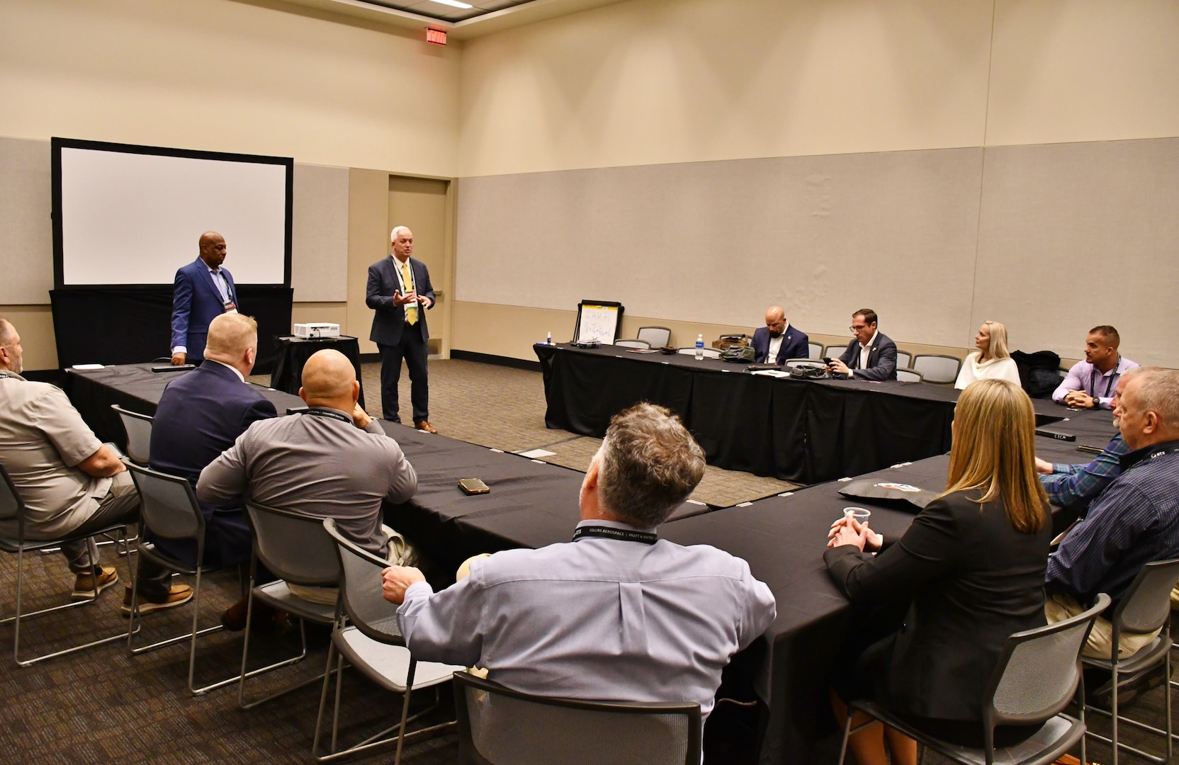 Man speaks to a small audience in a conference room.
