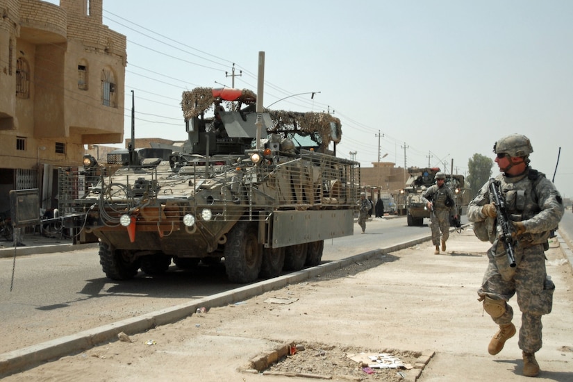 Staff Sgt. Andrew Frengel of Lebanon, Pa., other Soldiers and Stryker vehicles of A Troop, 2nd Squadron, 104th Cavalry Regiment, 56th Stryker Brigade Combat Team move through Sab al Bour, southwest of Taji, July 20. Pennsylvania Army National Guard Soldiers say they appreciate the versatility and the safety offered by the eight-wheeled vehicles after using them in Iraq since late January.