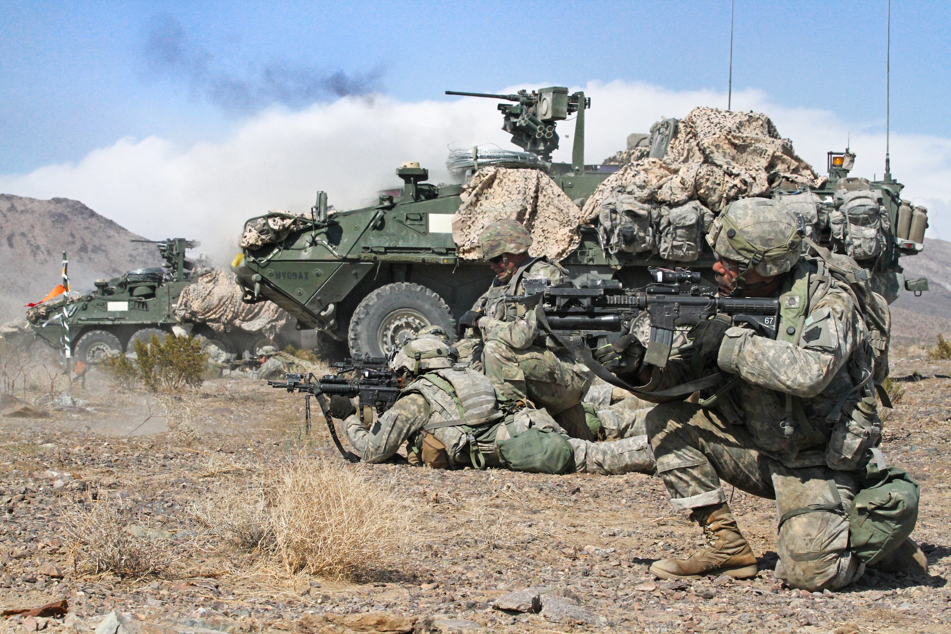 Infantrymen and Stryker crewmembers with Alpha Company, 2nd Battalion, 112th Infantry Regiment, 56th Stryker Brigade Combat Team, 28th Infantry Division, Pennsylvania Army National Guard provide support by fire for Charlie Company, engaging distant targets with M4 rifles, rifle-mounted M320 grenade launchers, M240s and M249 machine guns, and Stryker-mounted M2 .50 caliber machine guns during their training rotation at the National Training Center, Fort Irwin, California Aug. 15 (U.S. Army National Guard photo by Sgt. Shane Smith/released)