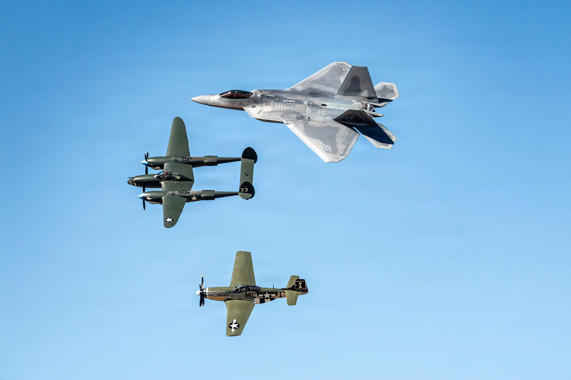 A U.S. Air Force F-22 Raptor aircraft flies in formation with a P-38 Lightning aircraft and a P-51 Mustang aircraft during the Heritage Flight Training Course at Davis-Monthan Air Force Base, Arizona, Feb. 28, 2026. The heritage flight formation showcases the rich legacy of U.S. air-power and the advancements made in aviation since the early days of the U.S. Army Air Corps. (U.S. Air Force photo by Senior Airman Jasmyne Bridgers-Matos)