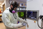 A man uses gloves to hold a tray of dental and orthodontic devices.