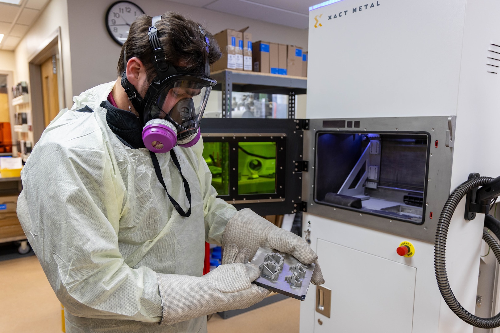 A man uses gloves to hold a tray of dental and orthodontic devices.