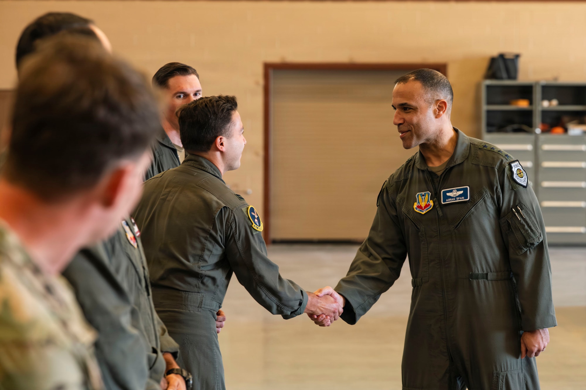 U.S. Air Force Gen. Adrian Spain, commander of Air Combat Command, coins Capt. Jon Toledo, an HC-130J Combat King II combat systems operator assigned to the 79th Rescue Squadron, at Davis-Monthan Air Force Base, Arizona, Feb. 26, 2026. Toledo was one of three Airmen from the 563rd Rescue Group recognized for outstanding performance. (U.S. Air Force photo by Airman 1st Class Samantha Melecio)