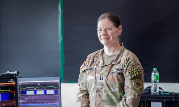 U.S. Army Capt. Brittany Chapman-Freed, space crew officer in charge assigned to 3rd Multi-Domain Task Force, stands beside a spectrum monitoring system during Exercise Cobra Gold 2026 at U-Tapao Royal Thai Navy Airfield, Thailand, Feb. 25, 2026.