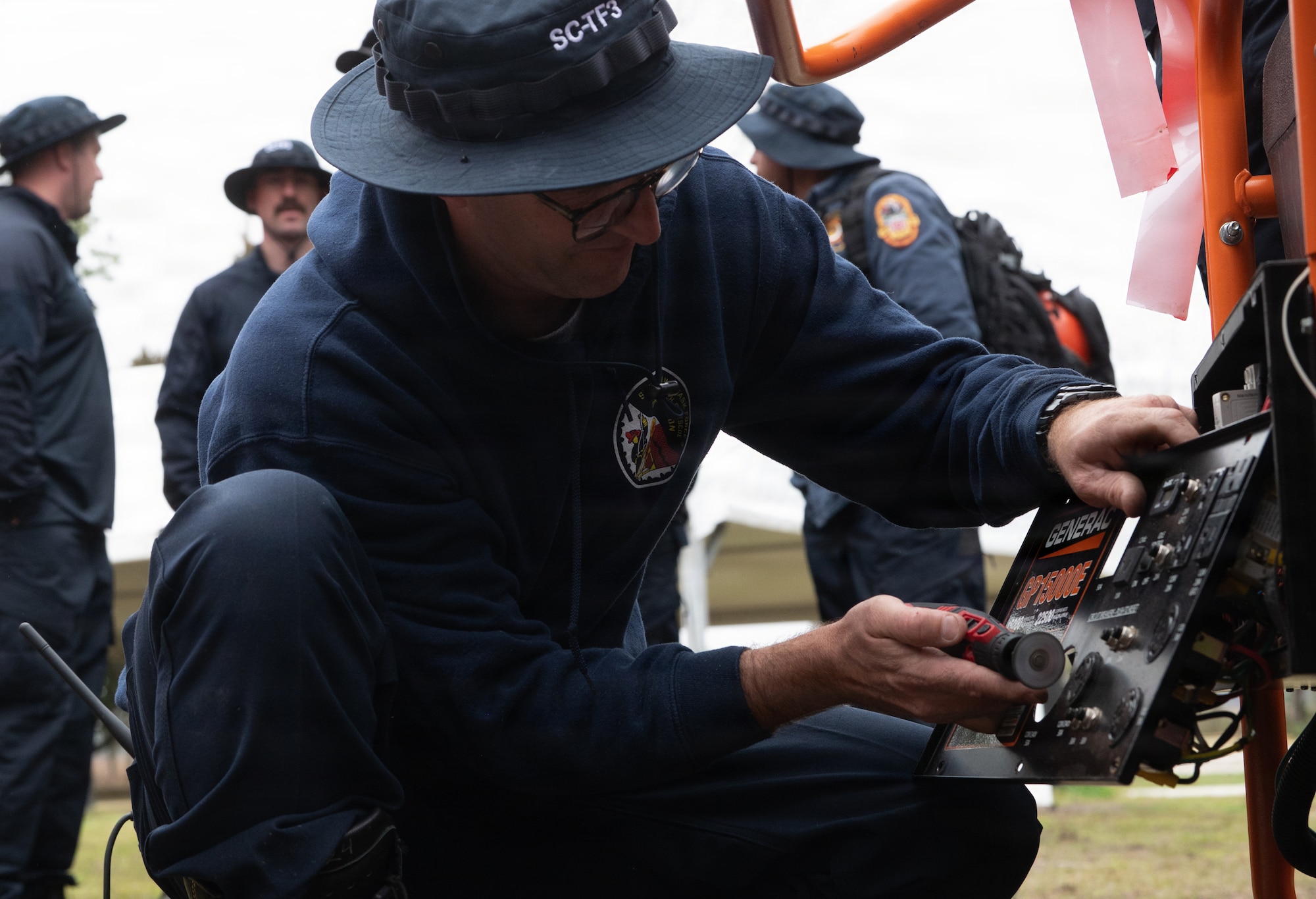 A Fire Department member repairs a generator.