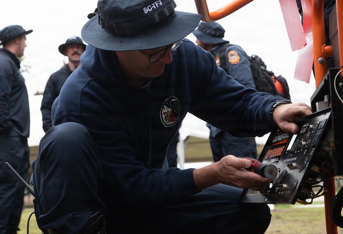 A Fire Department member repairs a generator.