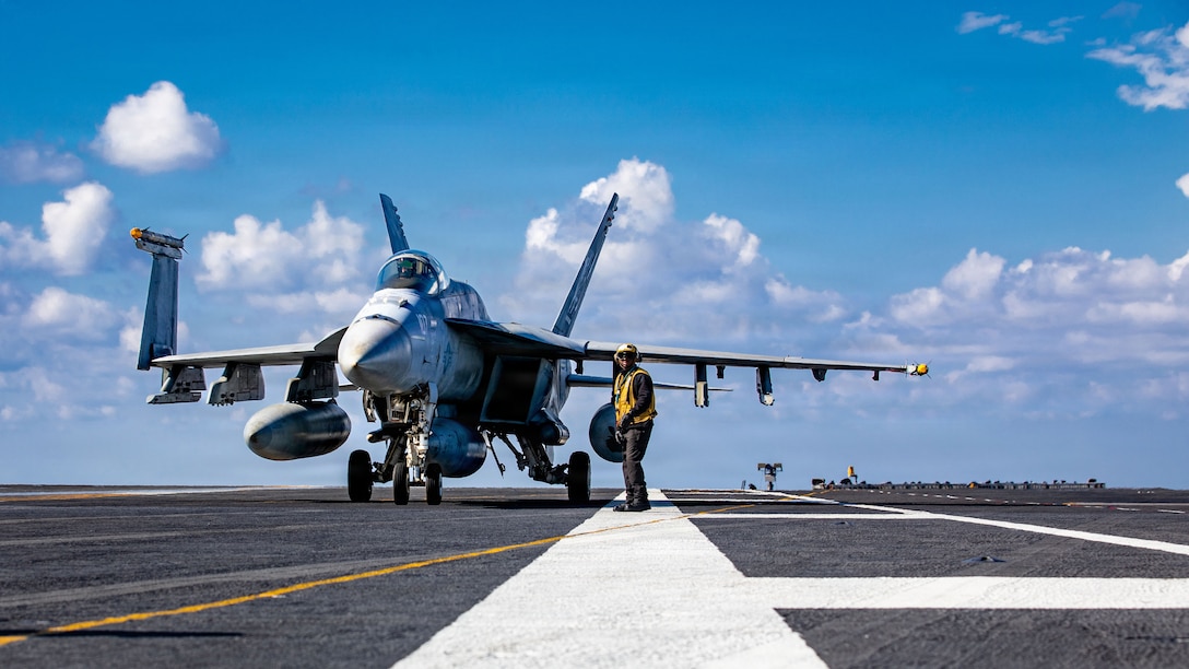 A U.S. Sailor signals to an F/A-18E Super Hornet aircraft, attached to Strike Fighter Squadron 87, on the flight deck of the world's largest aircraft carrier, USS Gerald R. Ford (CVN 78), while operating in support of Operation Epic Fury in the Eastern Mediterranean Sea, March 2, 2026. (U.S. Navy photo)