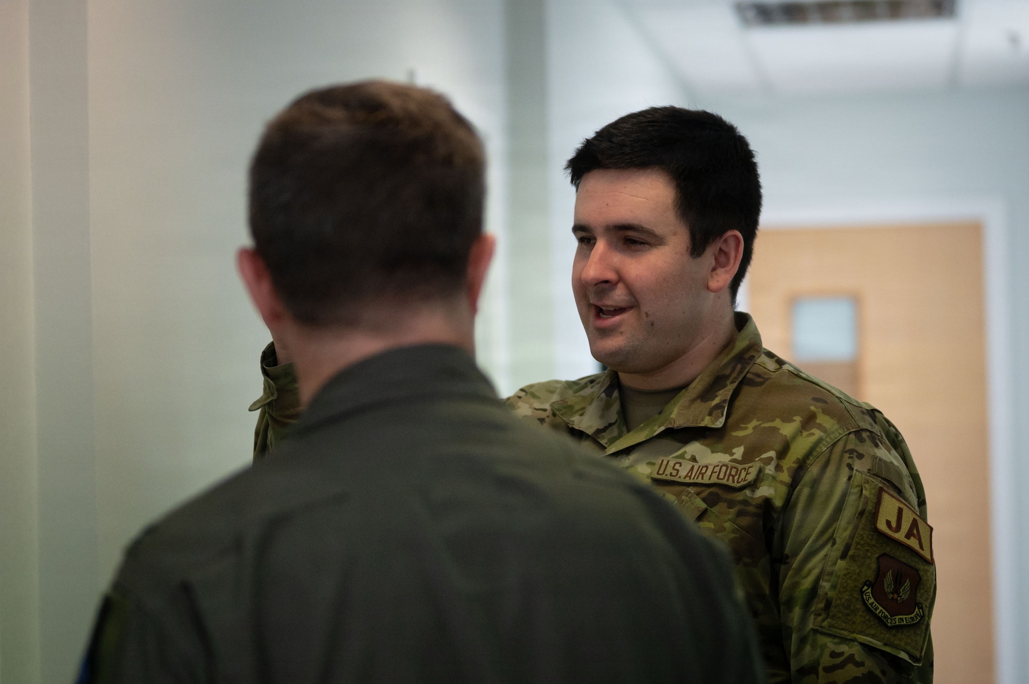 U.S. Air Force Senior Airman Mason Walch, right, 100th Air Refueling Wing civil law paralegal, briefs Col. Steven Byrum, 100th ARW commander, during a day in the life integration at RAF Mildenhall, England, Feb. 23, 2026.