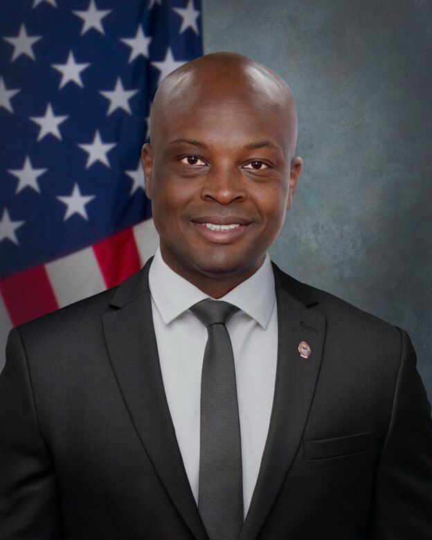 Man in suit in front of flag