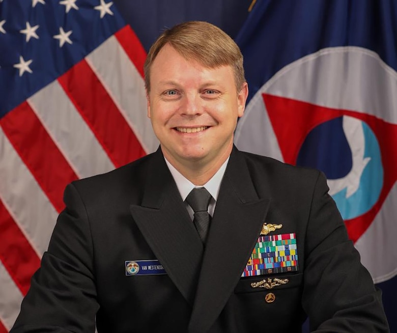 Officer in front of flag