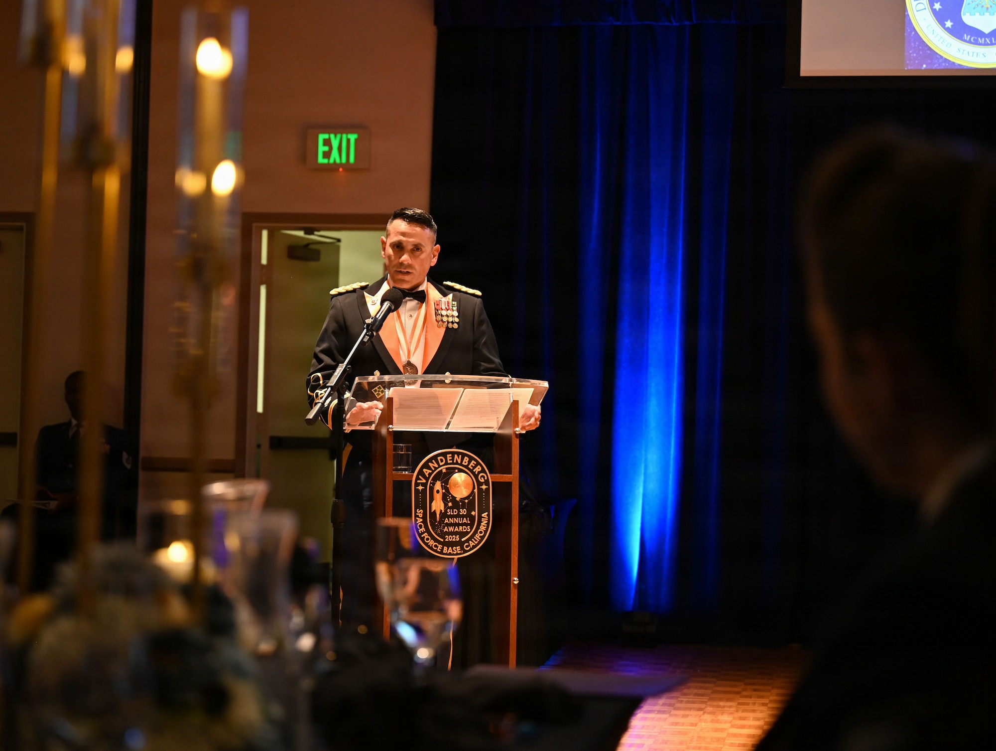 a person stands at a podium on a stage and speaks to a crowd