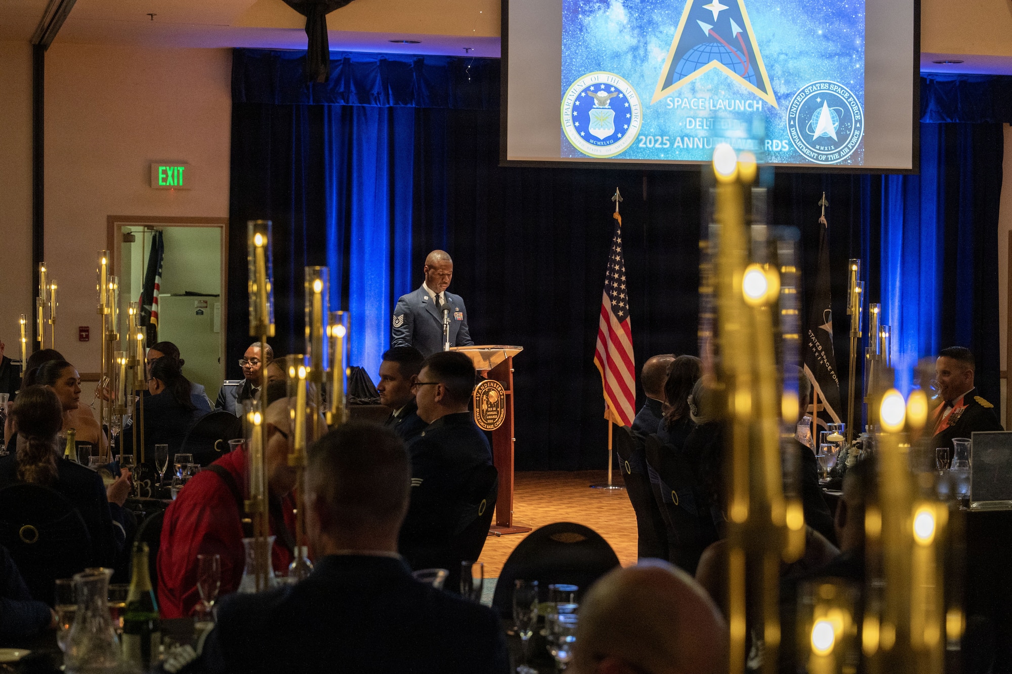 a man stand on a stage and speaks to a crows