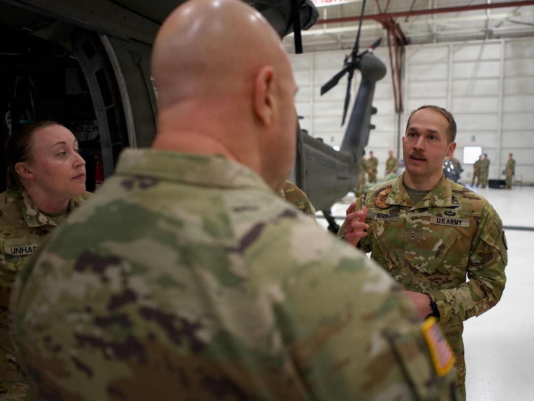 Alaska Army National Guard Chief Warrant Officer 2 David Berg, a UH-60 and HH-60 Black Hawk pilot with the 207th Aviation Troop Command, speaks with Lt. Gen. Jon Stubbs, Director of the Army National Guard, Feb. 20, 2026, at Joint Base Elmendorf-Richardson, about dynamic hoist operations.