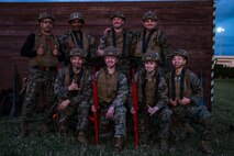 U.S. Marines with 5th Air Naval Gunfire Liaison Company, III Marine Expeditionary Force Information Group, and 9th Engineer Support Battalion, 3rd Marine Logistics Group, pose for a group photo a during Marine Corps Martial Arts Program black belt culminating event at Camp Hansen, Okinawa, Japan, Feb. 26, 2026.