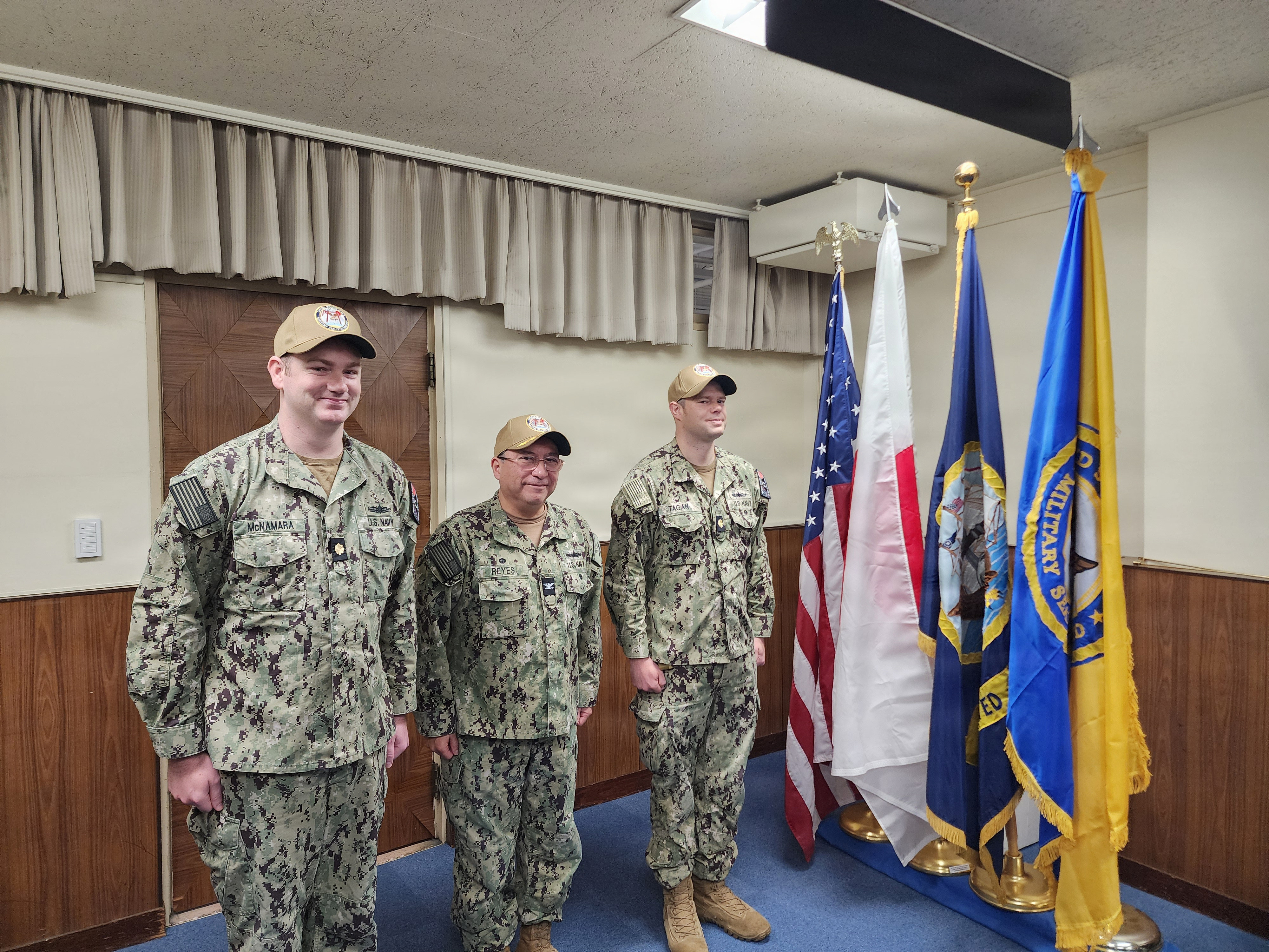 Left to right, Lt. Cmdr. Conor L. McNamara, incoming officer in charge (OIC), Military Sealift Command (MSC) Ship Support Unit (SSU) Japan; Capt. David L. Reyes, commodore, MSC Far East; and Lt. Cmdr. Shawn T. Tagan, outgoing OIC, MSC SSU Japan; stand at attention during a Change-of-Charge ceremony at Yokohama North Dock, Japan, March 2, 2026.