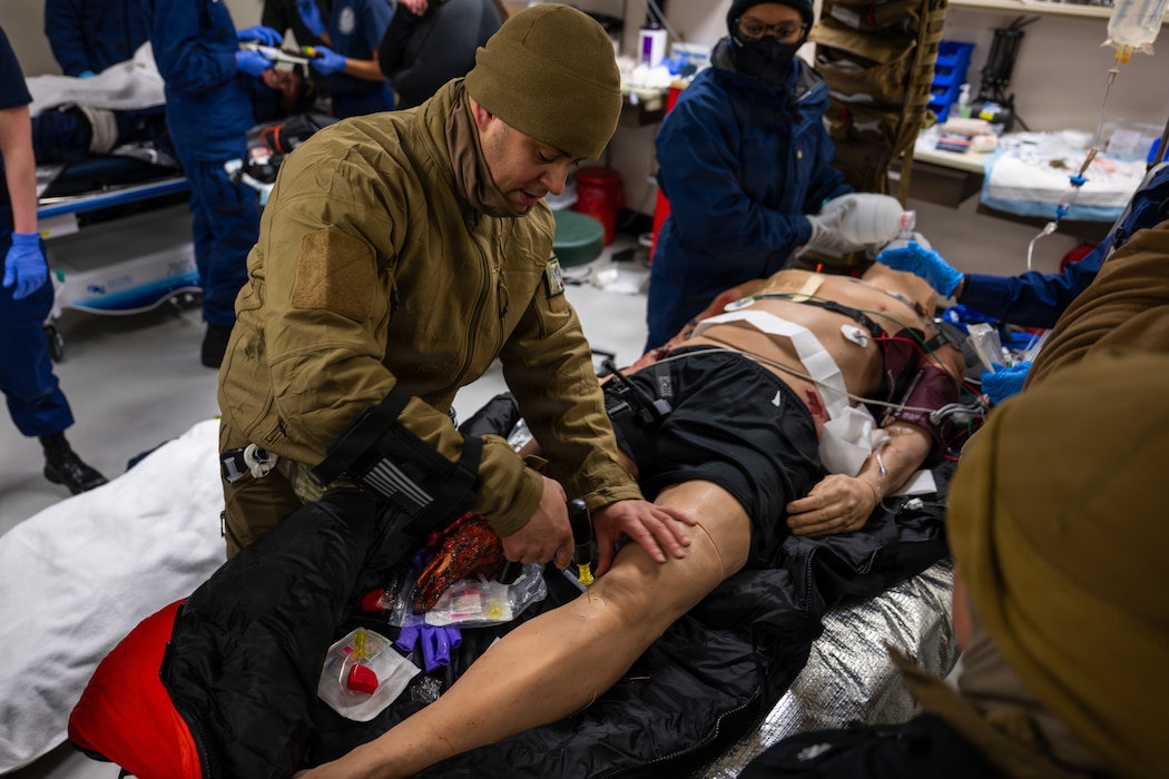 260225-G-GX036-1014 U.S. Navy Hospital Corpsman 1st Class Daniel Rodriguez, assigned to En-route Care System (ERCS) Team 52, establishes intraosseous access, used to deliver fluid and medication, on a medical training mannequin during a mass casualty drill as part of ARCTIC EDGE 26 (AE 26) in Kodiak, Alaska, Feb. 25, 2026. AE26 is a NORAD and U.S. Northern Command-led homeland defense exercise designed to improve readiness, demonstrate capabilities, and enhance Joint and Allied Force interoperability in the Arctic. (U.S. Coast Guard photo by Public Affairs Specialist 3rd Class Ashly Murphy)