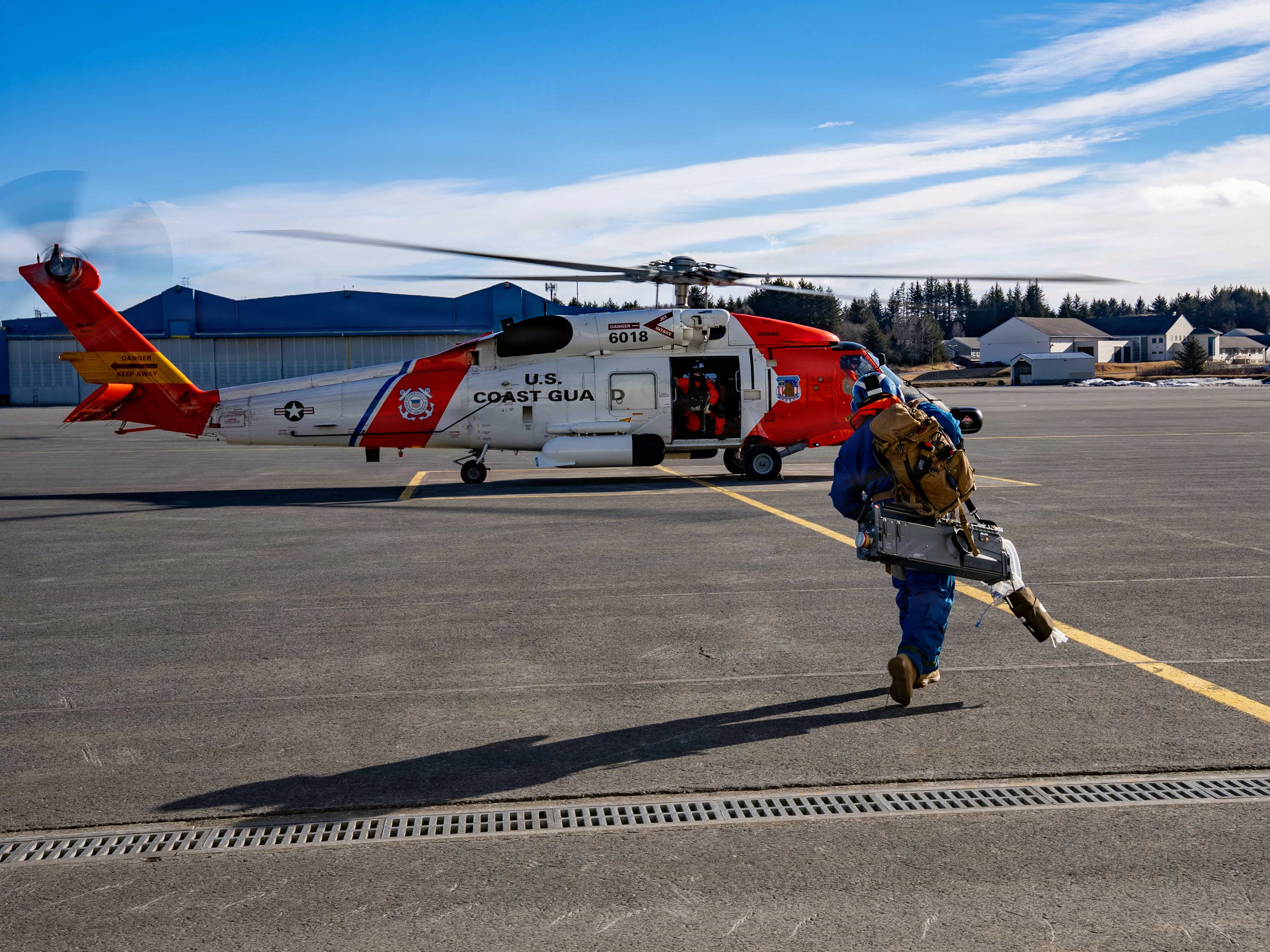U.S. Navy Hospital Corpsman 1st Class Daniel Rodriguez, an en-route care corpsman assigned to En-route Care System (ERCS) Team 52, approaches a U.S. Coast Guard MH-60 Jayhawk helicopter as part of a ship-to-shore patient transfer for ARCTIC EDGE 2026 in Kodiak, Alaska, Feb. 24, 2026. AE26 is a NORAD and U.S. Northern Command-led Homeland defense exercise designed to improve readiness, demonstrate capabilities, and enhance Joint and Allied Force interoperability in the Arctic. (U.S. Navy photo by Mass Communication Specialist 1st Class Abigayle Lutz)