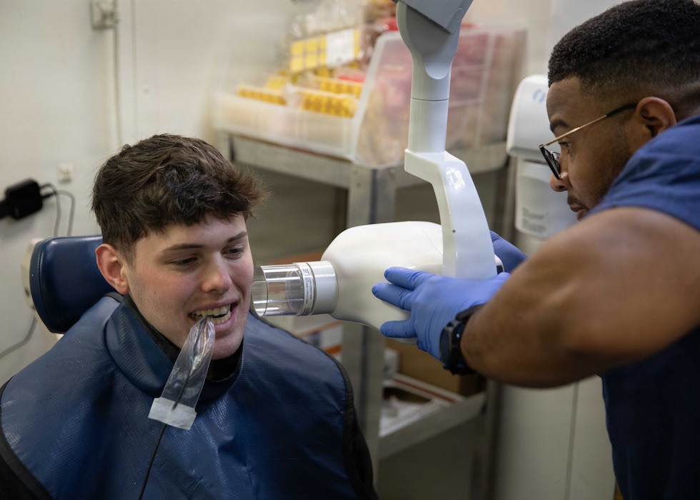 260224-N-FC769-1040 U.S. Navy Logistics Specialist 2nd Class Aidan Cosgrove, left, receives x-rays of his teeth by Hospital Corpsman 2nd Class Kenneth Massey aboard Nimitz-class aircraft carrier USS Dwight D. Eisenhower (CVN 69), Feb. 24, 2026. Eisenhower is moored at Norfolk Naval Shipyard for a Planned Incremental Availability maintenance period. (U.S. Navy photo by Mass Communication Specialist 3rd Class Jamison Sutton)