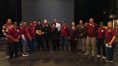Members of the 8th Infantry Regiment Illinois National Guard Association and the National Guard Association of Illinois honor Aaron Benjamin, the 2026 recipient of the Captain Walter H. Dyett Award during a ceremony March 2 at the Walter H. Dyett High School for the Fine Arts in Chicago.