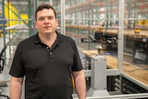 Photo of Corey Katsak standing next to a small uncrewed aircraft system