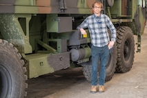 Photo of Scott Kratochvil leaning on a military vehicle