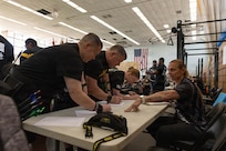 Adriane Wilson, an operations specialist with the Army Recovery Program, helps competitors in the archery competition sign in and prepare their scoresheets March 3, 2026.