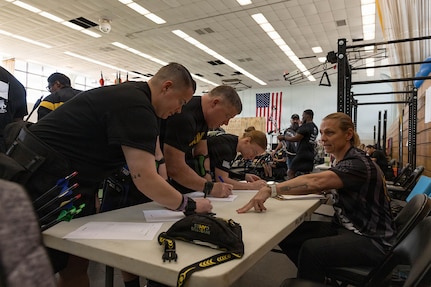 Adriane Wilson, an operations specialist with the Army Recovery Program, helps competitors in the archery competition sign in and prepare their scoresheets March 3, 2026.