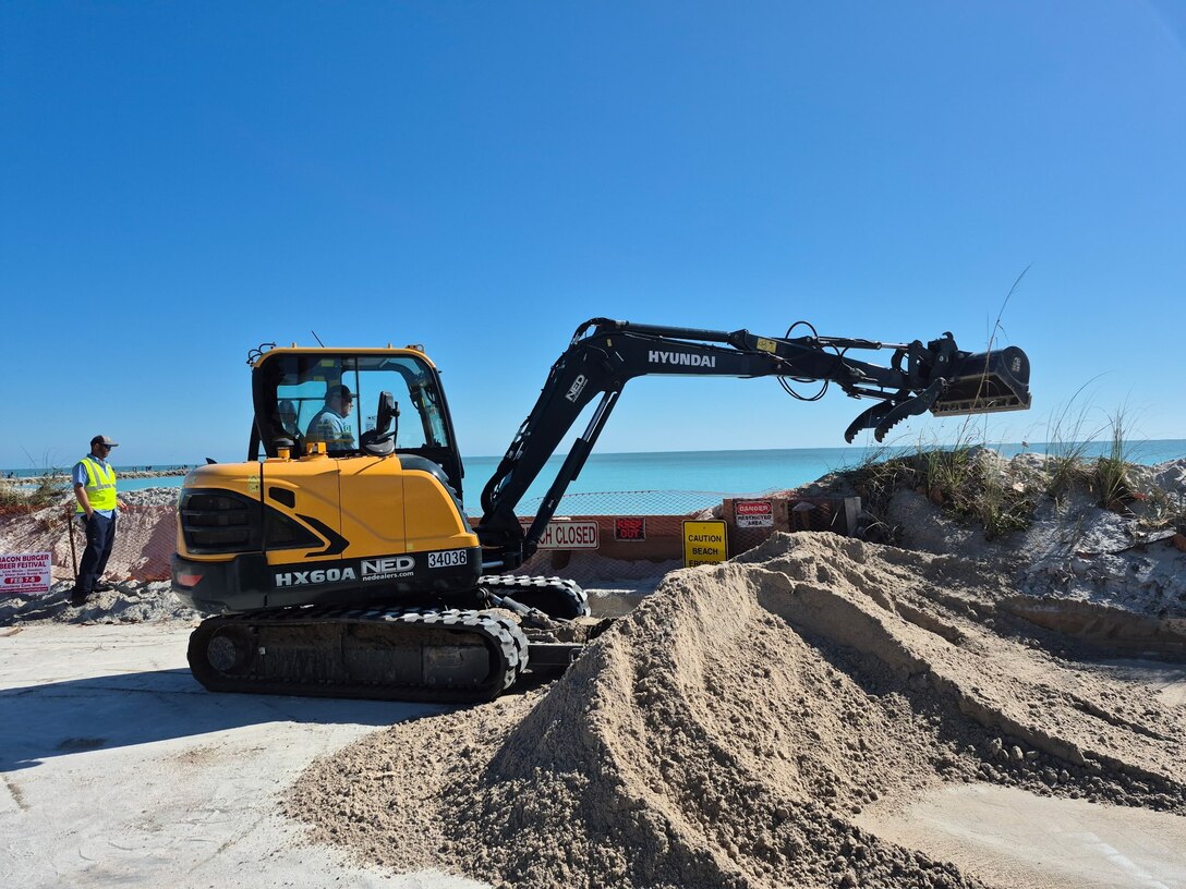 An excavator operated by a City of Fort Pierce employee prepares to move freshly delivered sand into place along the shoreline at Jetty Park on Saturday, Feb. 14, 2026, as workers race to protect a nearby roadway, homes and underground utilities from an eroding shoreline. (U.S. Army Corps of Engineers photo by Ronnie Shawn Huebner)