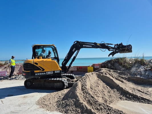 An excavator operated by a City of Fort Pierce employee prepares to move freshly delivered sand into place along the shoreline at Jetty Park on Saturday, Feb. 14, 2026, as workers race to protect a nearby roadway, homes and underground utilities from an eroding shoreline. (U.S. Army Corps of Engineers photo by Ronnie Shawn Huebner)