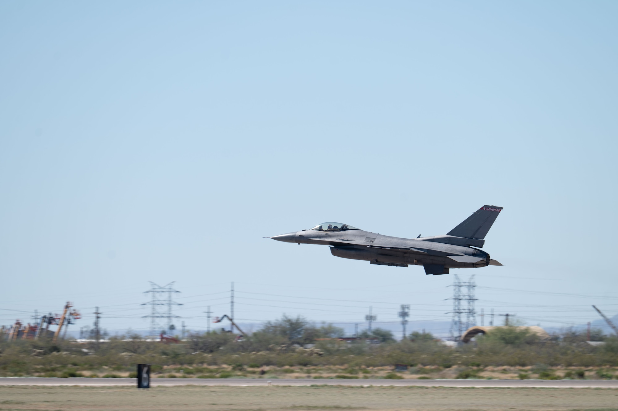 U.S. Air Force Maj. Taylor “FEMA” Heister, F-16 Demonstration Team pilot and commander, flies over the Heritage Flight Training Course at Davis-Monthan Air Force Base, Arizona, Feb. 28, 2026. The demonstration profile can include up to 18 maneuvers, with the pilot experiencing up to nine times the force of gravity, or nine Gs, and traveling just under the speed of sound at 700 miles per hour. (U.S. Air Force Photo by Airman 1st Class Jaden Kidd)