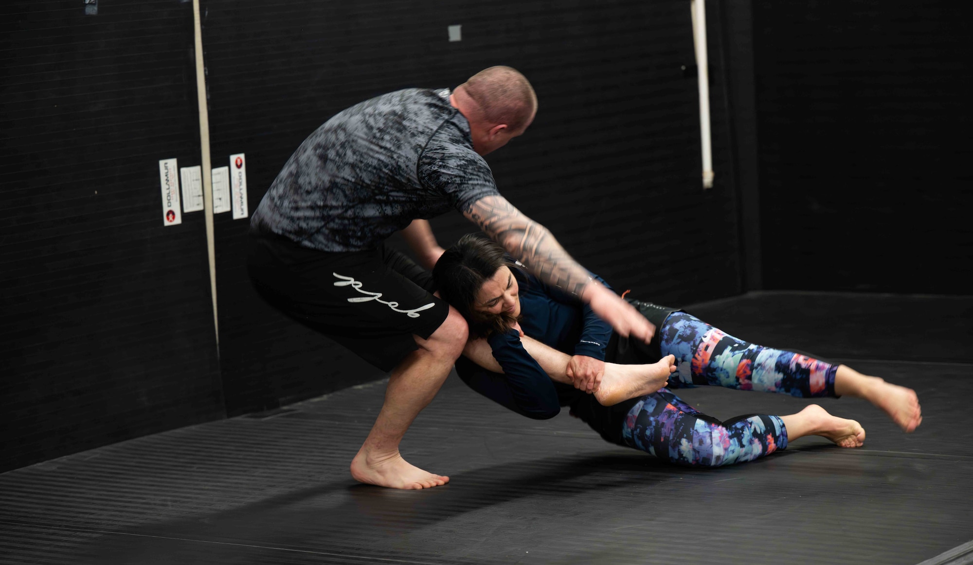Master Sgt. Travis Hallinger, 931st Wing Staff Agency first sergeant, and Major Jamie Briske, 22nd Medical Group Operational Support Team Flight Commander, engage in jiu-jitsu combat training on McConnell Air Force Base, Kansas, Feb. 26, 2026. Jiu-jitsu is a grappling-based martial art that focuses on ground fighting, using leverage, technique, and joint locks or chokes to subdue opponents. (U.S. Air Force photo by Airman 1st Class Tavian Sims)