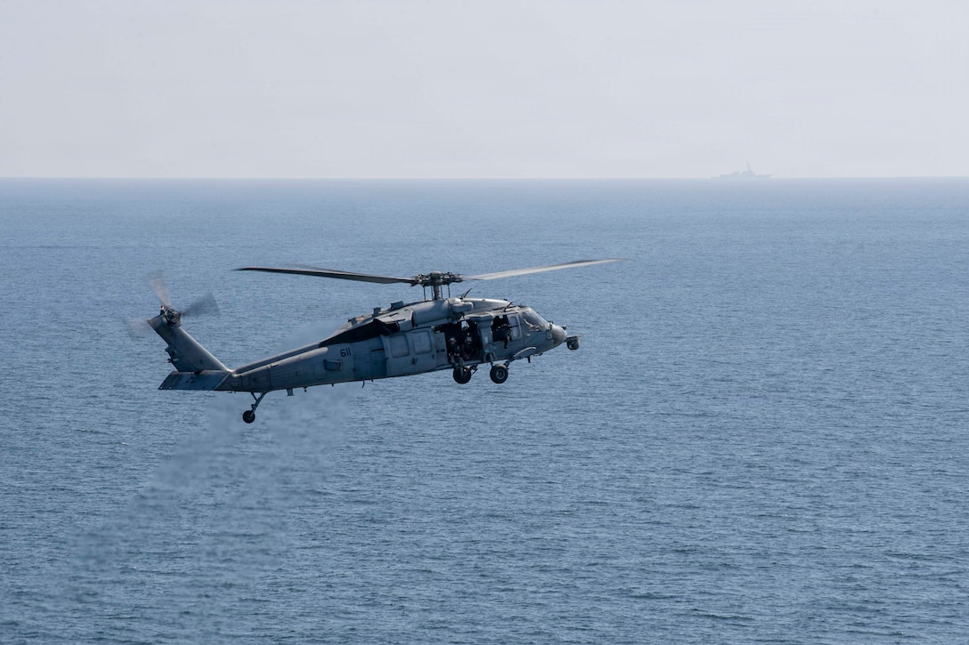 An MH-60S Sea Hawk helicopter, attached to Helicopter Sea Combat Squadron (HSC) 14, flies by Nimitz-class aircraft carrier USS Abraham Lincoln (CVN 72) in support of Operation Epic Fury, March 3, 2026. (U.S. Navy photo)