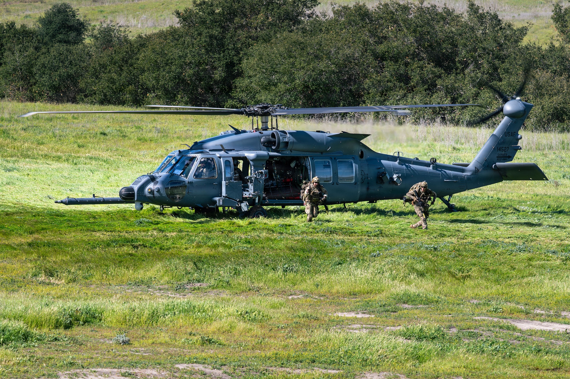 U.S. Air Force pararescuemen assigned to the 48th Rescue Squadron arrive at the scene of a simulated mass casualty in an HH-60W Jolly Green II helicopter during Exercise Red Flag-Rescue 26-1 at Marine Corps Base Camp Pendleton, California, Feb. 20, 2026. The exercise tests participants’ ability to execute Agile Combat Employment with precision, deploying follow-on forces and adapting to rapidly evolving threats while maintaining operational tempo. (U.S. Air Force photo by Senior Airman Jasmyne Bridgers-Matos)