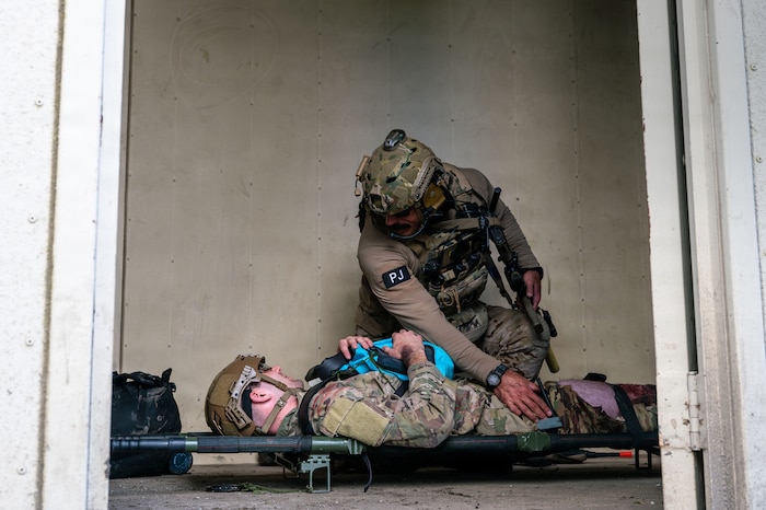 A U.S. Air Force pararescueman assigned to the 48th Rescue Squadron examines a simulated casualty during Exercise Red Flag-Rescue 26-1 at Marine Corps Base Camp Pendleton, California, Feb. 20, 2026. Participants are challenged to think critically and creatively, showcasing their ability to adapt and innovate in the face of dynamic operational demands. (U.S. Air Force photo by Senior Airman Jasmyne Bridgers-Matos)
