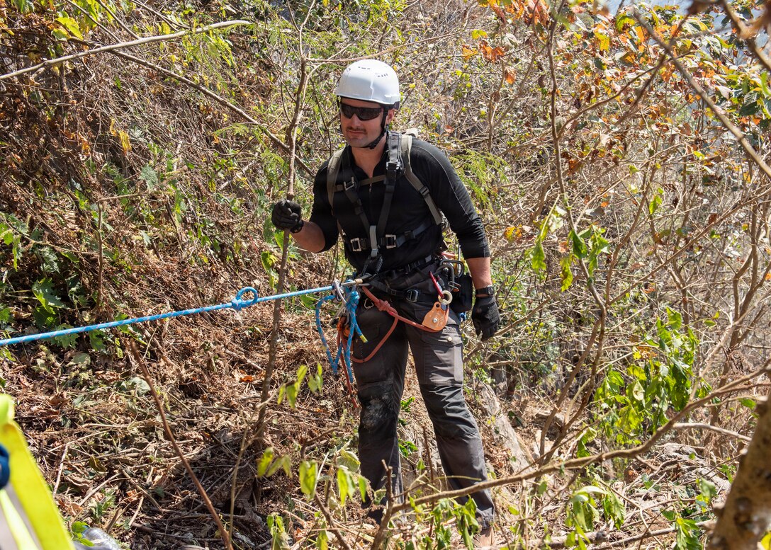 U.S. Army Staff Sgt. Zachary Bailey, Defense POW/MIA Accounting Agency independent duty medical technician, prepares to rappel a cliff face during a simulated real-world casualty evacuation during a recovery mission in Laos, Jan. 28, 2026.