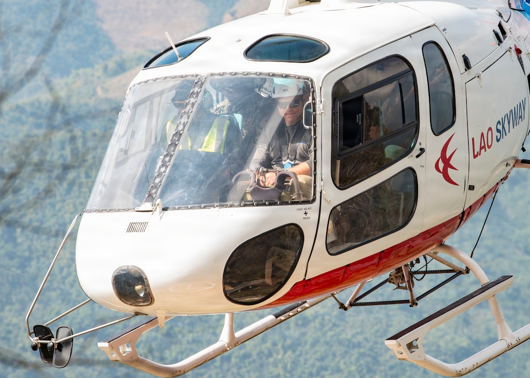 Khamla Phomsichanh, deputy director of Lao Skyway, and U.S. Navy Hospital Corpsman 2nd Class Connor Dougherty, Defense POW/MIA Accounting Agency medic, fly in a Lao Skyway Helicopter during a recovery mission in Laos, Jan. 28, 2026.
