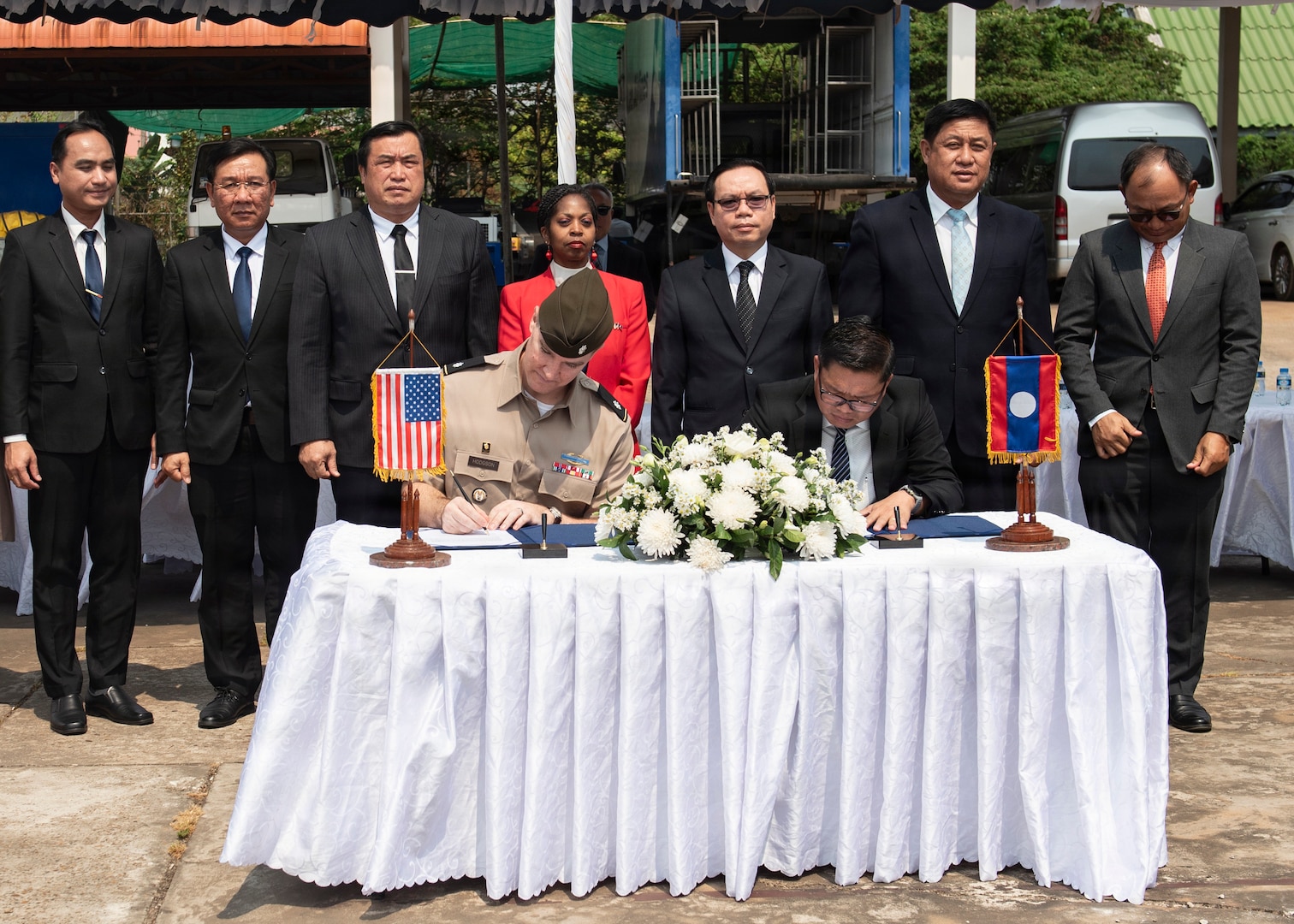 U.S. Army Lt. Col. Carl Hodgson, Laos Detachment 3 commander and Bounchanh Xayalath, director of MIA division, Europe-Americas Department, ministry of foreign affairs, sign transfer documents during a repatriation ceremony in Laos, Feb. 23, 2026.
