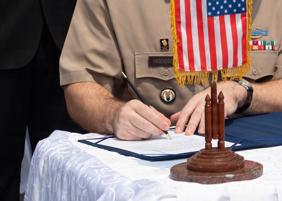 U.S. Army Lt. Col. Carl Hodgson, Laos Detachment 3 commander signs transfer documents during a repatriation ceremony in Laos, Feb. 23, 2026.